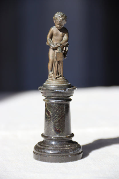 Miniature Bronze Figurine of Cupid Sharpening His Points on Marble Pedestal